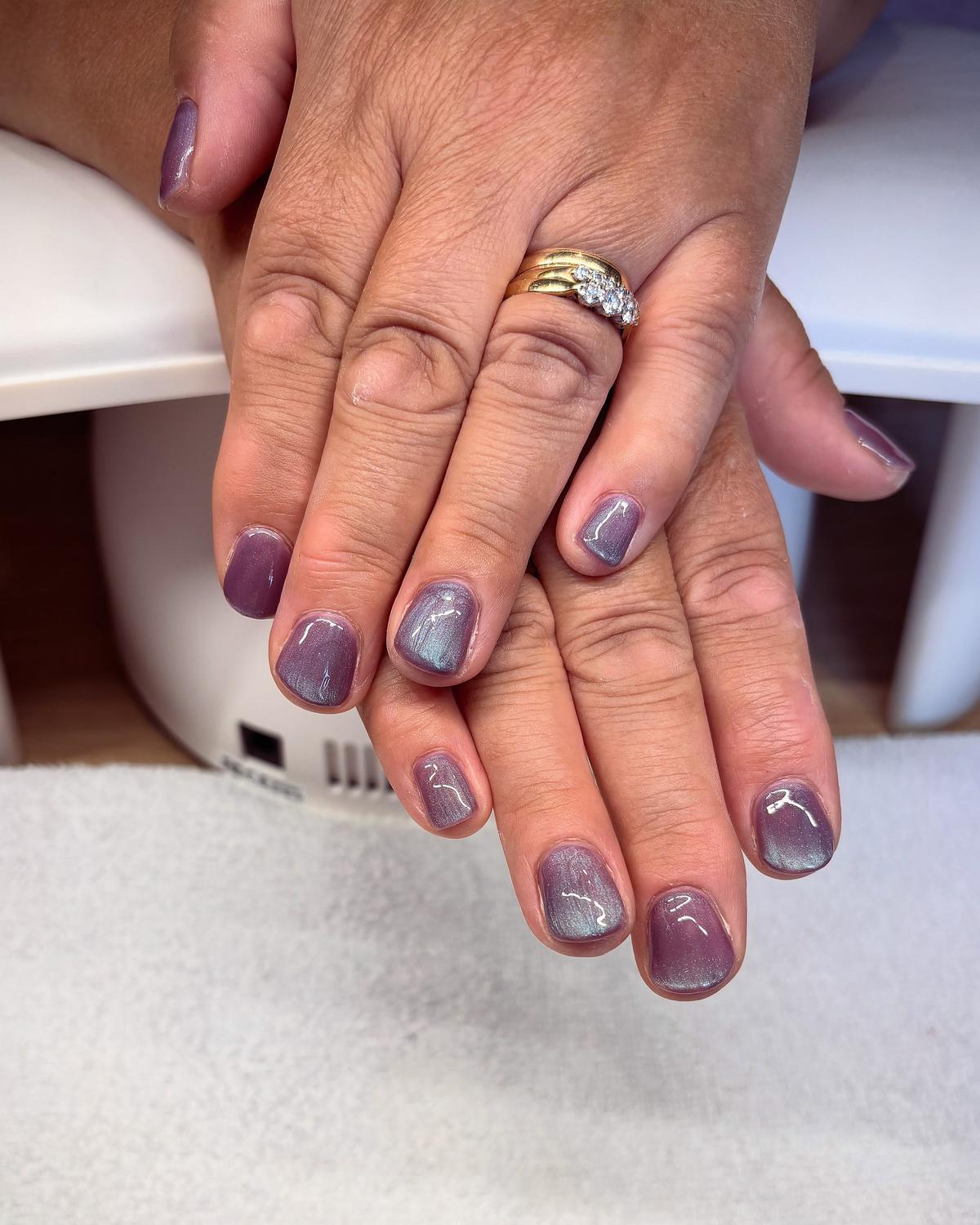 Short plum-lilac cat-eye gel nails with a silvery shimmer